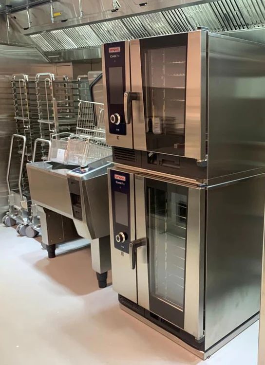 Dois fornos combinados empilhados em inox instalados em cozinha profissional