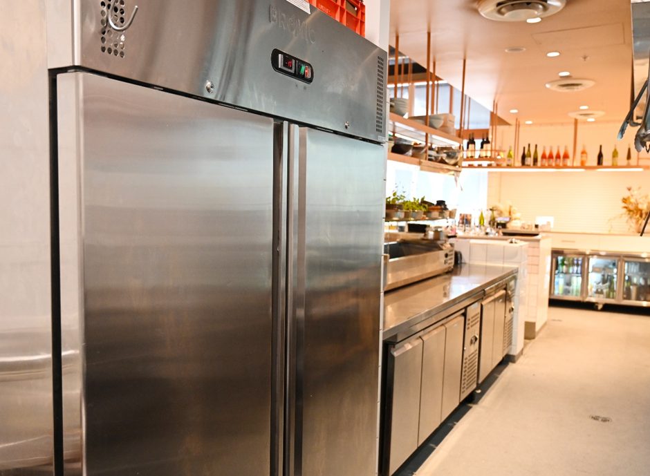 Refrigeradores verticais em aço inox alinhados em praça de produção