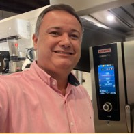 Leonardo Bianchini ao lado do painel de um forno combinado